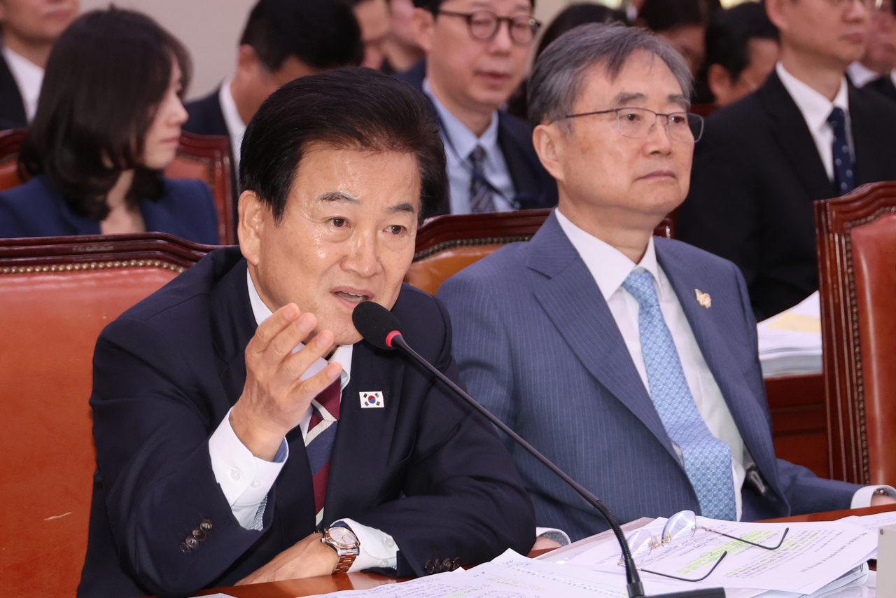 Unification Minister Chung Dong-young (left) responds to an inquiry by a lawmaker during a parliamentary audit session of his ministry on Oct. 28, 2025. (Yonhap)