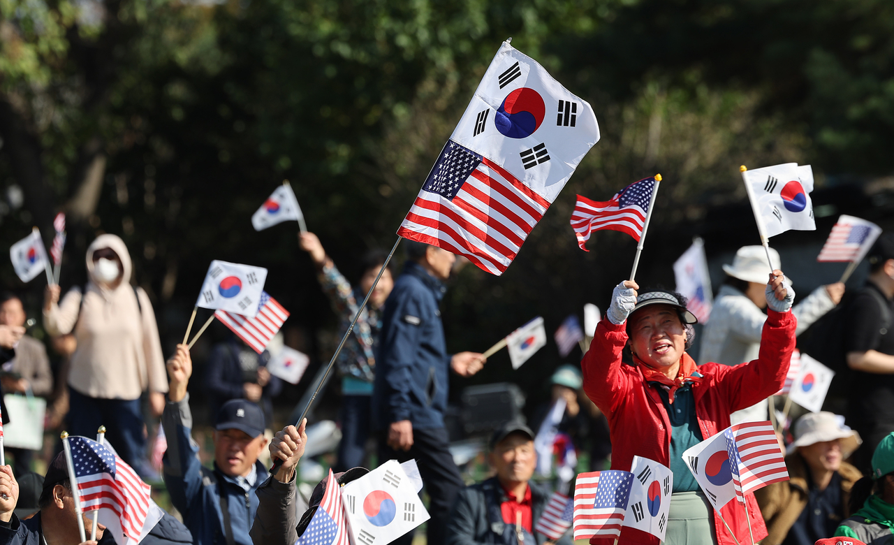 Demonstrators wave Korean and American flags, welcoming US President Donald Trump to South Korea on Wednesday, in central Gyeongju, North Gyeongsang Province. (Newsis)