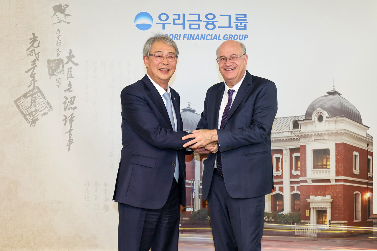 Woori Financial Group Chair Yim Jong-yong (left) and Inter-American Development Bank President Ilan Goldfajn shake hands during a meeting at Woori’s headquarters in central Seoul on Monday. (Woori Financial Group)