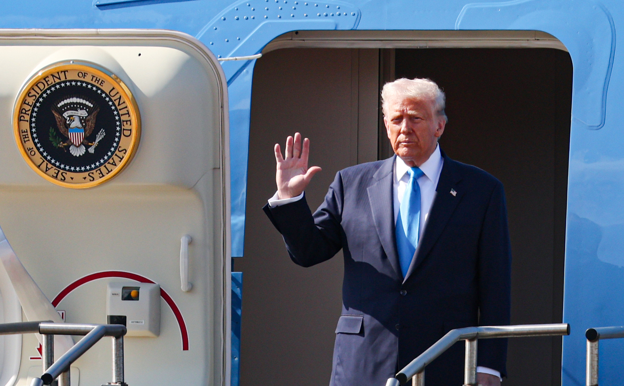 US President Donald Trump waves from Air Force One after arriving at Gimhae International Airport in Busan on Wednesday. (Yonhap)