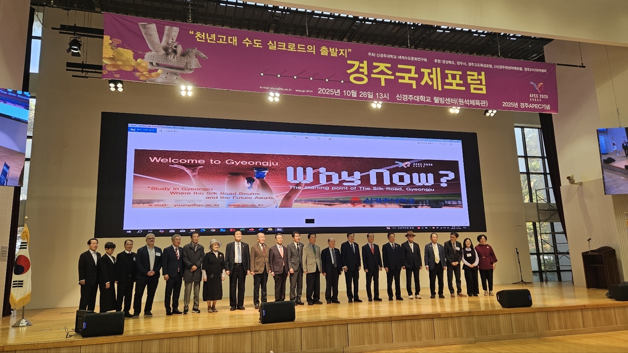 Participants in a special forum in Gyeongju, North Gyeongsang Province, commemorating the APEC summit, pose for a photo on a stage at Singyeongju University on Sunday. (Singyeongju University)