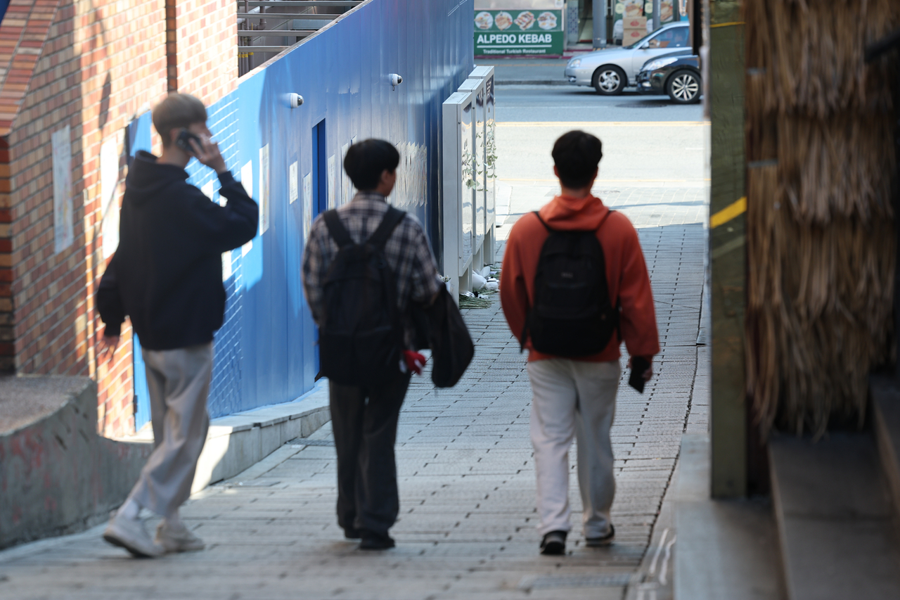 Pedestrians on Tuesday walk in an alley in Itaewon, central Seoul, where a crowd crush on Oct. 29, 2022, killed 159 and injured 195. (Yonhap)