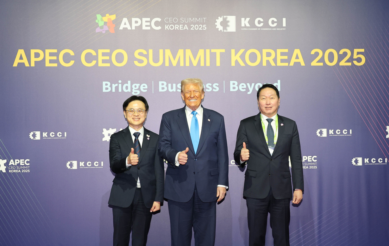 US President Donald Trump (center) poses for a photo with Korean Industry Minister Kim Jung-kwan (left) and Chey Tae-won, chair of the Korea Chamber of Commerce and Industry and SK Group (right), during the 2025 APEC CEO Summit Korea 2025 held at the Gyeongju Arts Center in Gyeongju, North Gyeongsang Province, Wednesday. (KCCI)