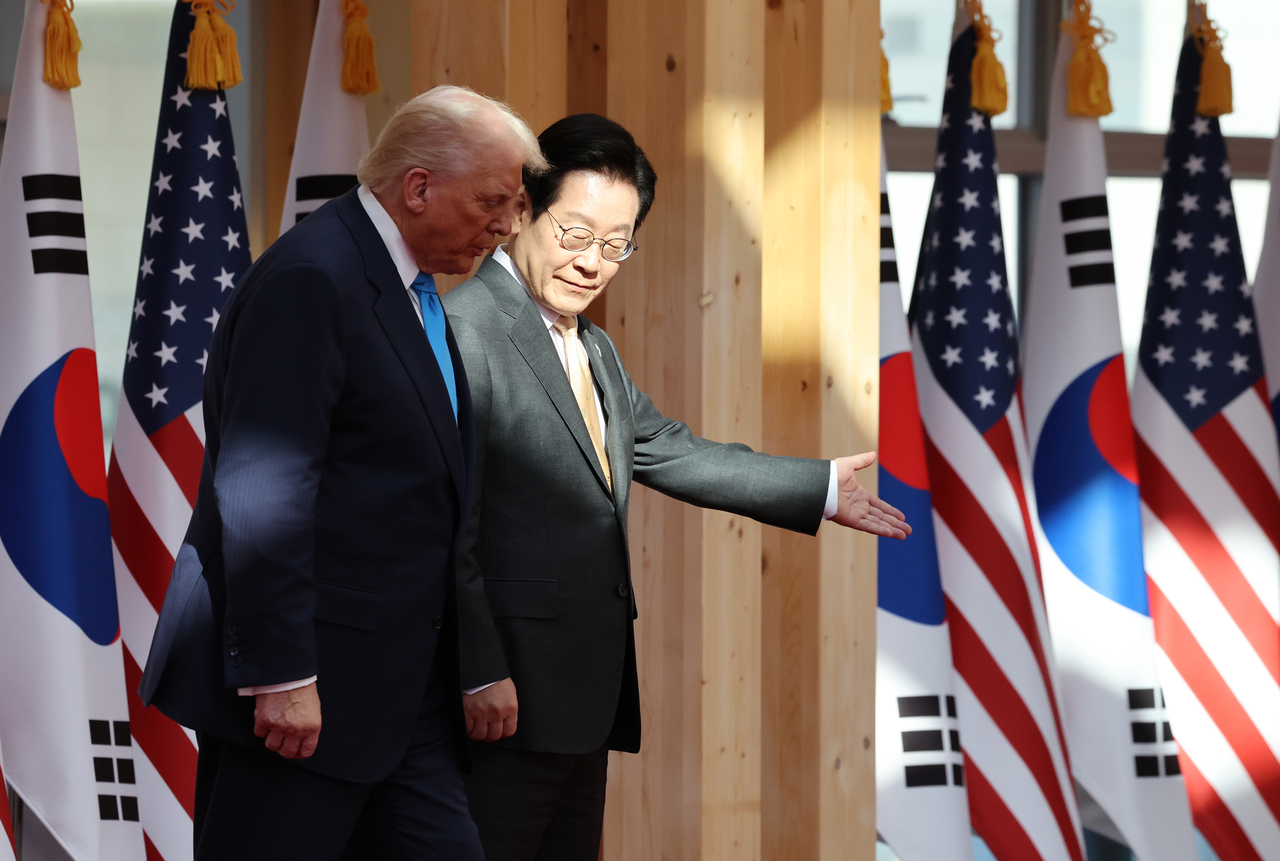 President Lee Jae Myung (right) and visiting US President Donald Trump walk toward the summit venue at the Gyeongju National Museum in Gyeongju,  North Gyeongsang Province, on Wednesday. (Yonhap)