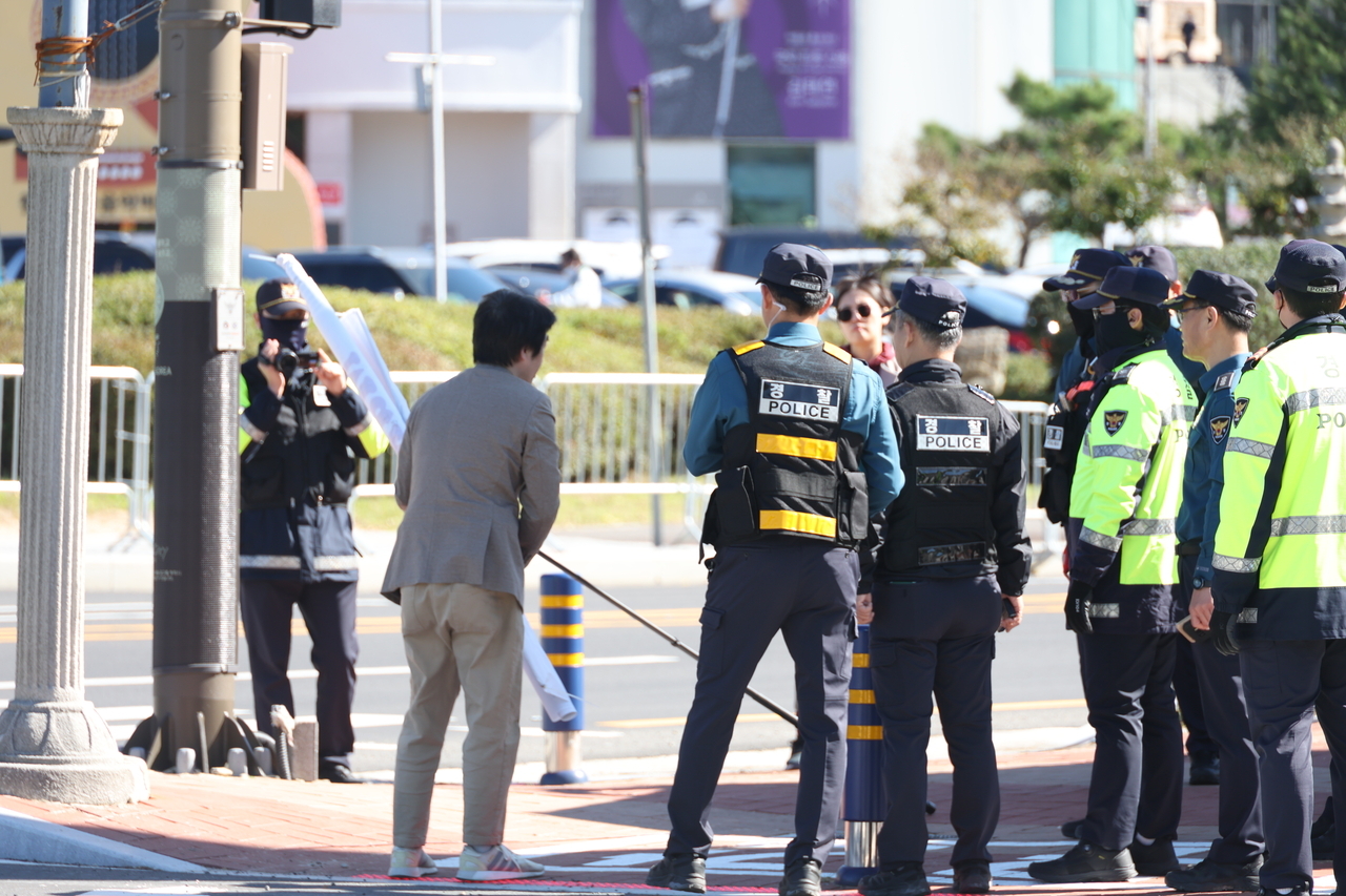 Police restrict an unregistered protester in front of the APEC venue in Gyeongju, North Gyeongsang Province, Tuesday, (Yonhap)