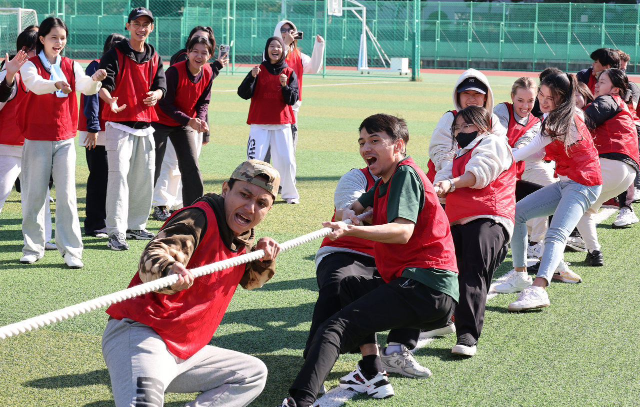 International students participate in a tug-of-war at the PKNU Global Sports Day held at the main stadium of Pukyong National University in Busan, Wednesday. (Yonhap)