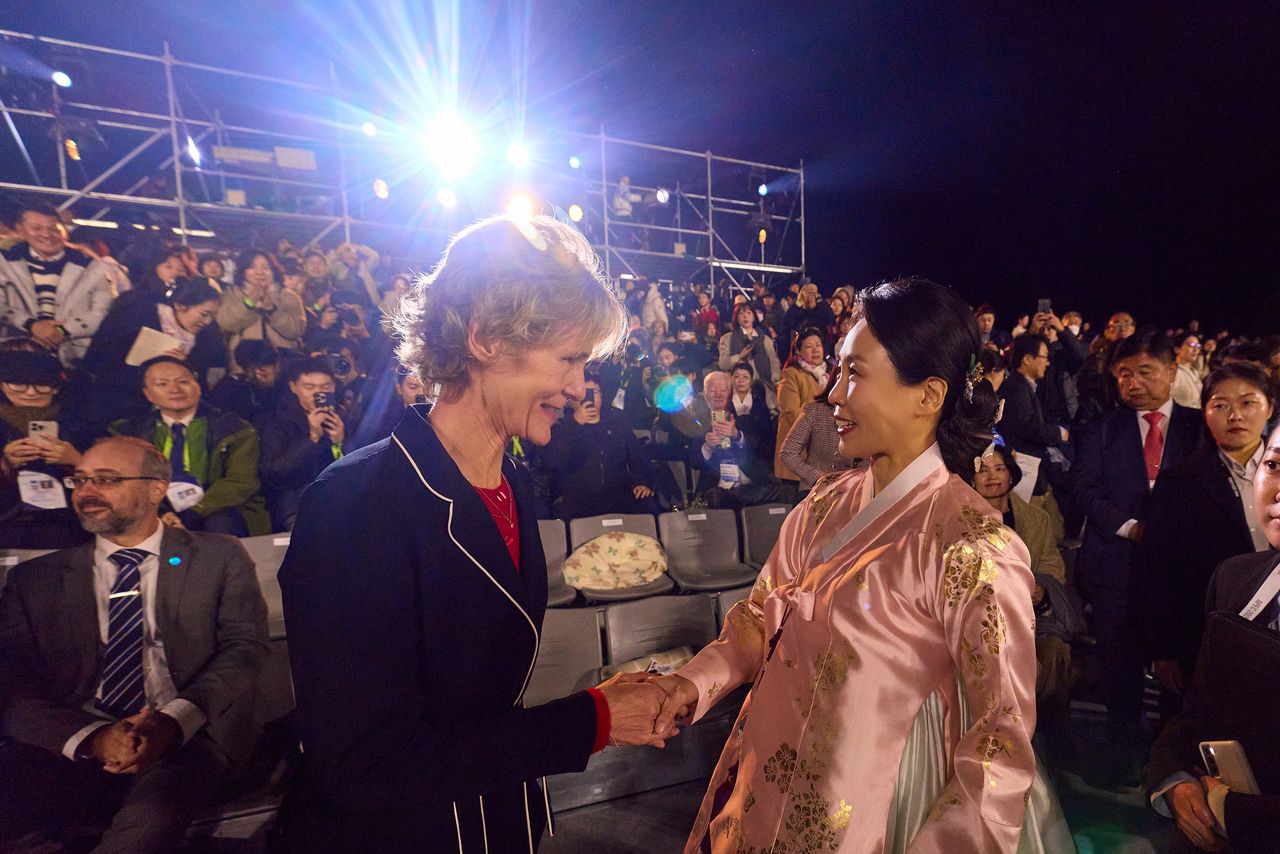 First lady Kim Hea Kyung (right) shakes hands with Diana Fox Carney, the wife of Canadian Prime Minister Mark Carney, during a hanbok fashion show in Gyeongju, North Gyeongsang Province, Wednesday. (Presidential office)