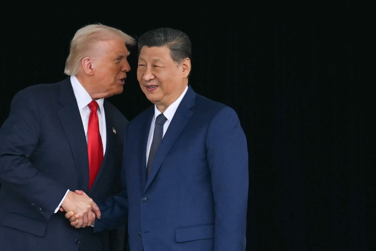 President Trump and China's President Xi Jinping shake hands after holding talks at Gimhae Air Base, located next to Gimhae International Airport in Busan, on Thursday.  (AFP-Yonhap)