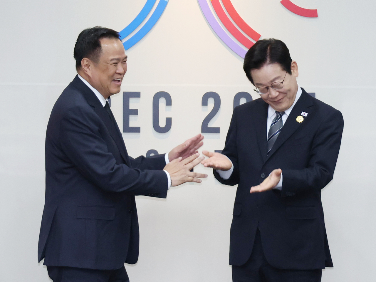President Lee Jae Myung (right) and Thai Prime Minister Anutin Charnvirakul yield their positions to each other for a commemorative photo during their bilateral meeting at the APEC summit venue in Gyeongju, North Gyeongsang Province, Thursday. (Yonhap)