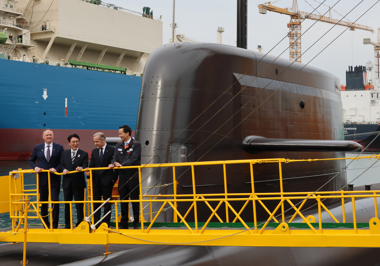 Canada's Minister of National Defense David McGuinty (from left), South Korea's Prime Minister Kim Min-seok, Canada's Prime Minister Mark Carney and Hanwha Vice Chairman Kim Dong-kwan are seen during Carney's visit to South Korean shipmaker Hanwha Ocean's shipyard in Geoje, South Gyeongsang Province, on Thursday. (Yonhap)