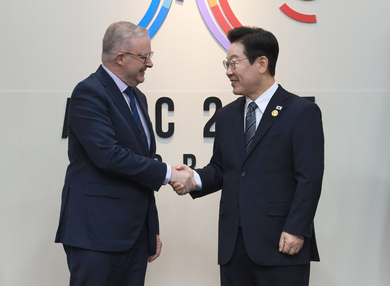 South Korean President Lee Jae Myung (right) and Australian Prime Minister Anthony Albanese shake hands at their summit in Gyeongju, North Gyeongsang Province, Thursday. (Joint Press Corps via Yonhap)