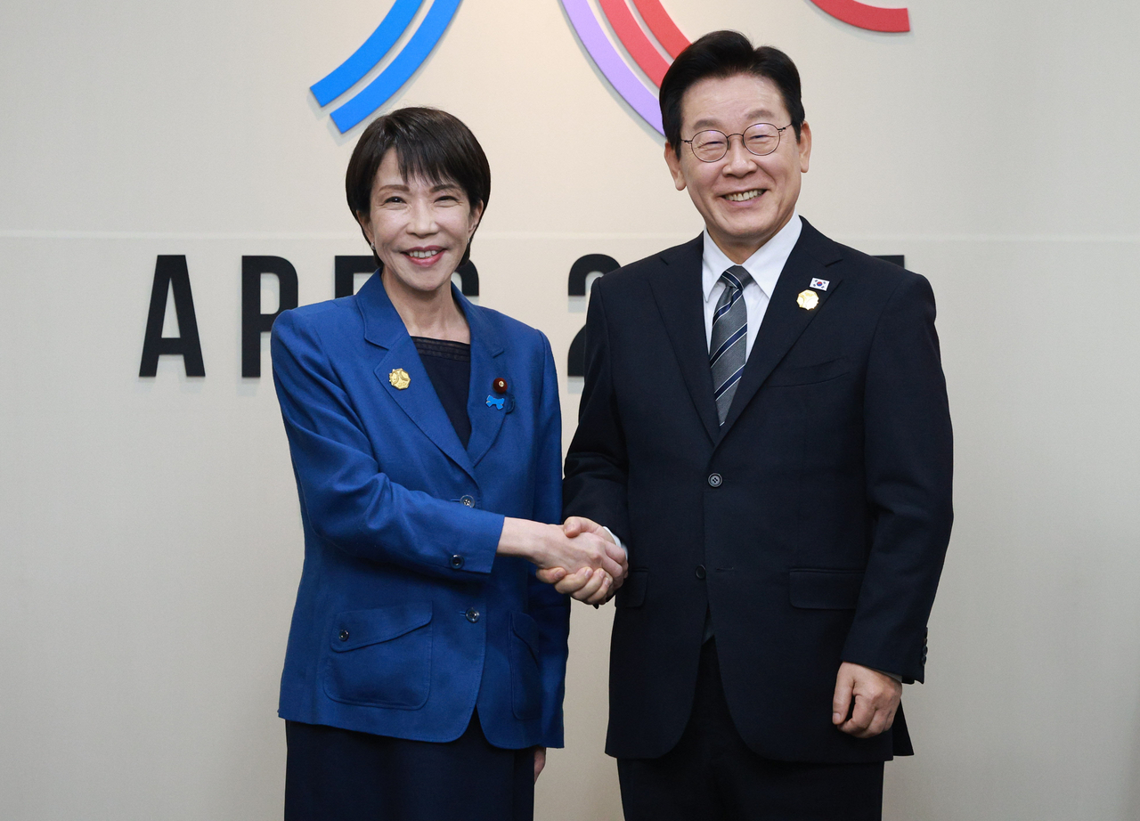 South Korean President Lee Jae Myung and Japanese Prime Minister Sanae Takaichi (left) shake hands before their first bilateral summit in Gyeongju, North Gyeongsang Province, on Thursday. (Joint Press Corps via Yonhap)