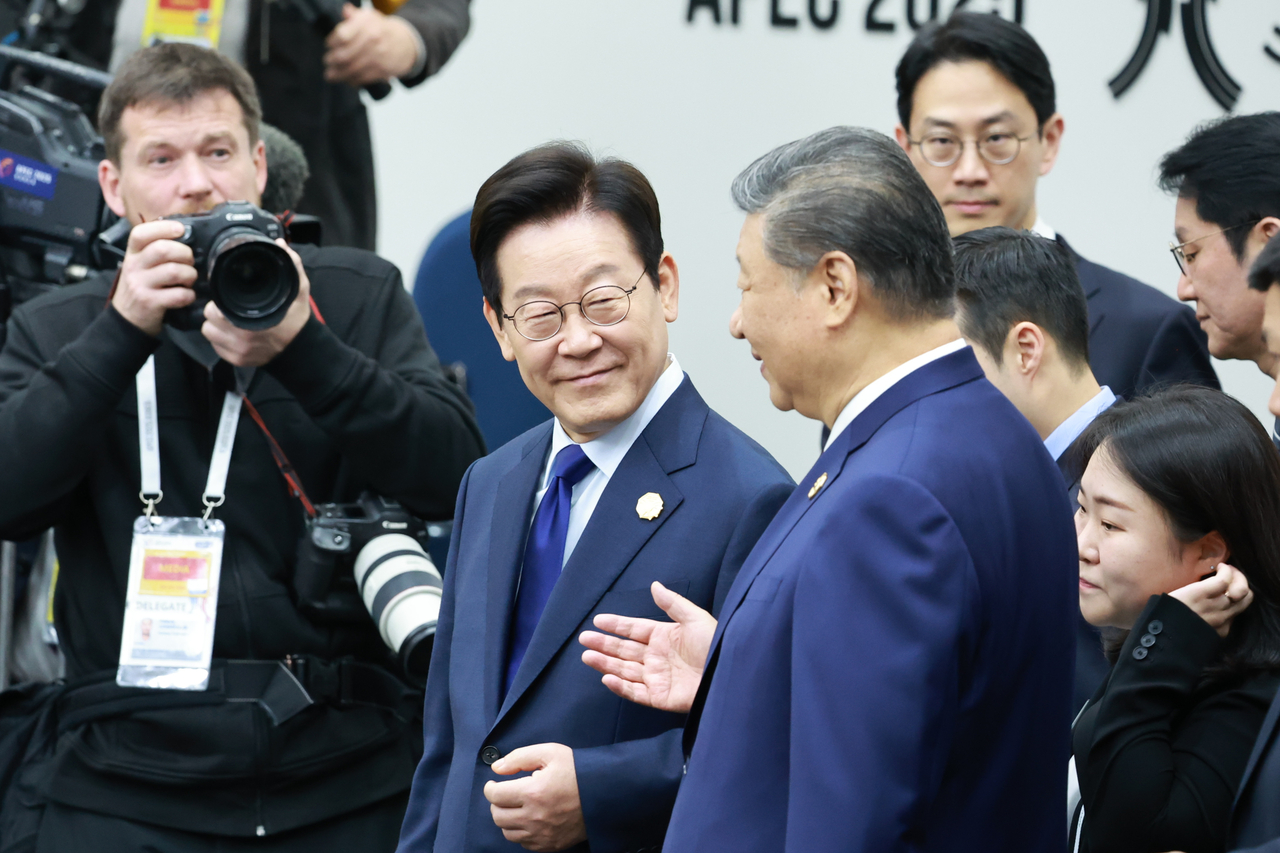 South Korean President Lee Jae Myung (center left) talks with Chinese President Xi Jinping during the first session of the Asia-Pacific Economic Cooperation conferences at the Gyeongju Hwabaek International Convention Center in Gyeongju, North Gyeongsang Province, Friday. (Yonhap)