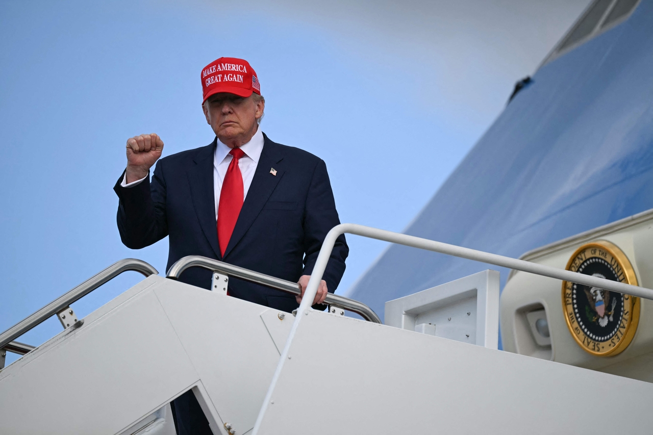 US President Donald Trump gestures to the press as he steps off Air Force One upon arrival at Joint Base Andrews in Maryland on Friday.   AFP-Yonhap