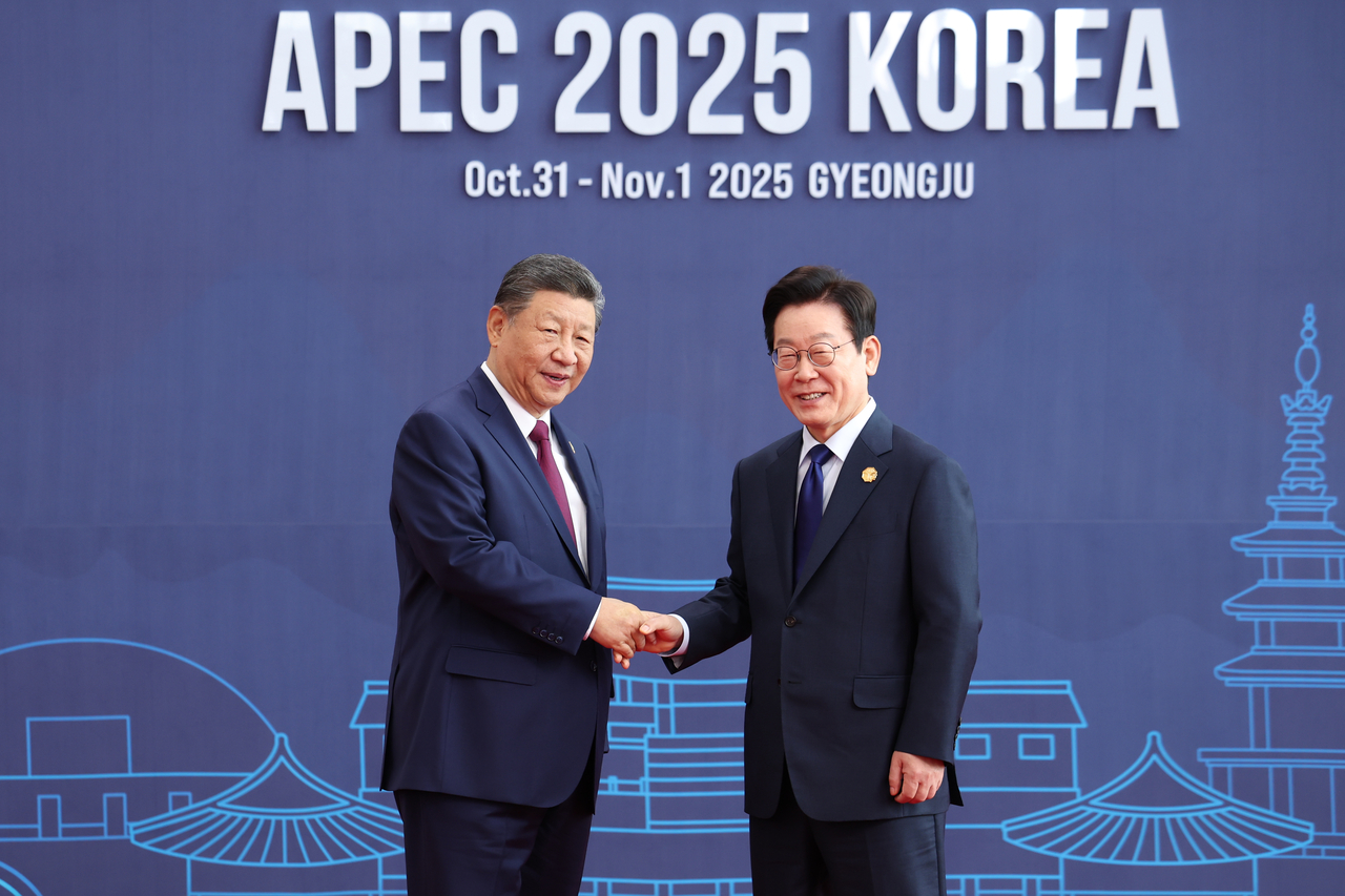 President Lee Jae Myung (R) shakes hands with Chinese President Xi Jinping upon Xi's arrival at the Gyeongju Hwabaek International Convention Center, the main venue of the Asia-Pacific Economic Cooperation summit, on Friday. (Yonhap)