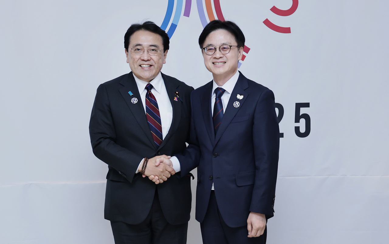 Industry Minister Kim Jung-kwan (right) shakes hands with his Japanese counterpart, Ryosei Akazawa, during their bilateral meeting held on the sidelines of the APEC leaders' summit in Gyeongju, North Gyeongsang Province, Friday. (Ministry of Trade, Industry and Resources)