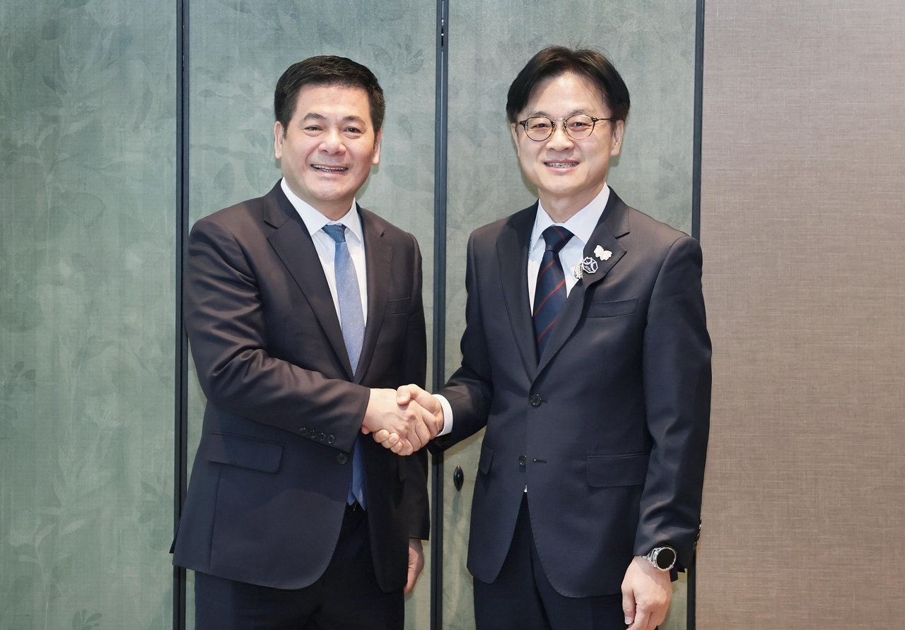 Industry Minister Kim Jung-kwan (right) shakes hands with his Vietnamese counterpart, Nguyen Hong Dien, during their bilateral meeting held on the sidelines of the APEC leaders' summit in Gyeongju, North Gyeongsang Province, Friday. (Ministry of Trade, Industry and Resources)