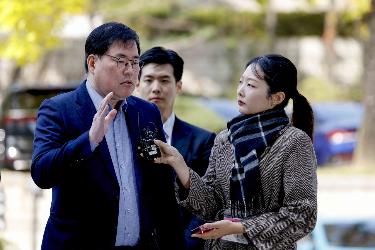 Former acting president of Seongnam Development Corp. Yoo Dong-gyu (left) enters Seoul Central District Court ahead of his trial on the Seongnam development scandal on Friday. (Yonhap)