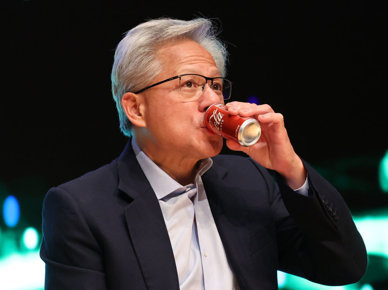 Nvidia CEO Jensen Huang takes a sip of Coke during a press conference held at the Gyeongju Arts Center in North Gyeongsang Province on Friday. (Im Se-jun/The Korea Herald)