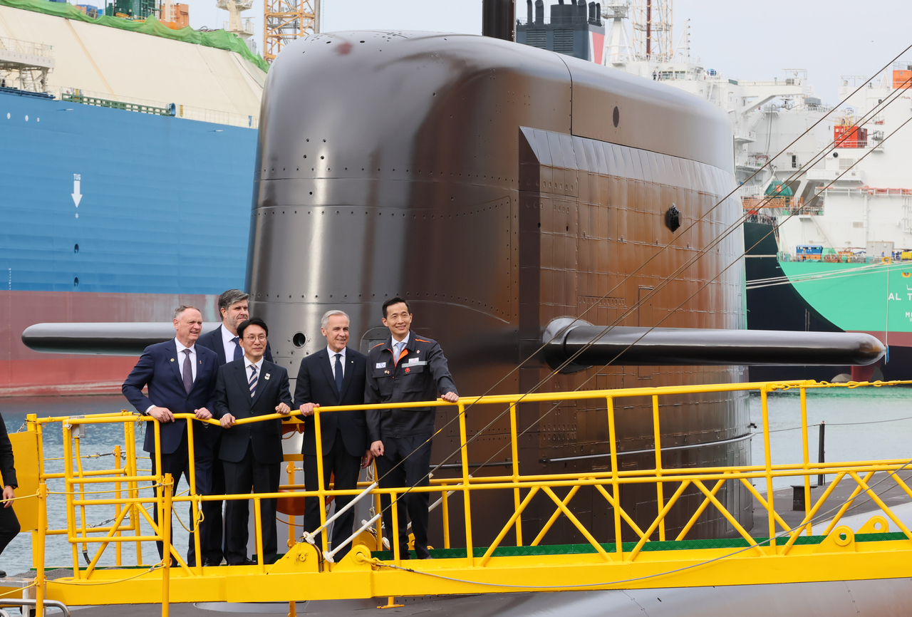 Canadian Prime Minister Mark Carney (second from right) and South Korean Prime Minister Kim Min-seok (third left) inspect South Korea's newly launched submarine, the Jang Young-sil, on Thursday at Hanhwa Ocean's Geojae Shipyard. (Yonhap)