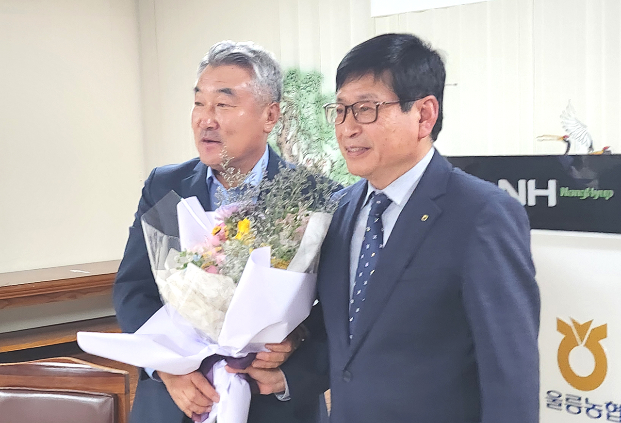 정종학 울릉농협장(오른쪽)이 충남 부여 축협 정만교 조합장에게 먼길을 오신데 대한 감사의 뜻으로 꽃다발을 전달하고 있다.[울릉농협 제공]