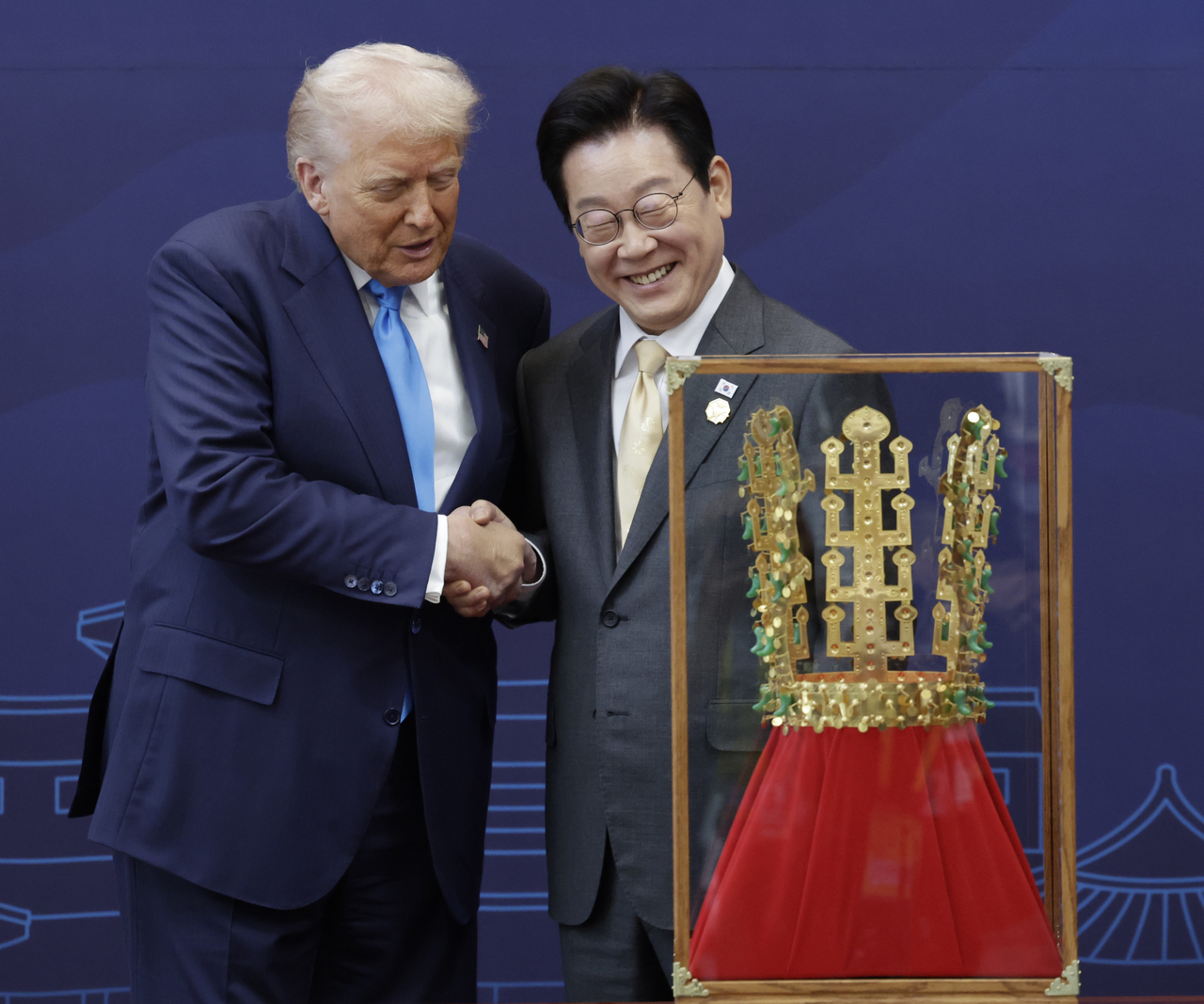 President Lee Jae Myung (right) shakes hands with US President Donald Trump after presenting him with a replica of the Cheonmachong gold crown at the Gyeongju National Museum in North Gyeongsang Province on Wednesday. (Yonhap)