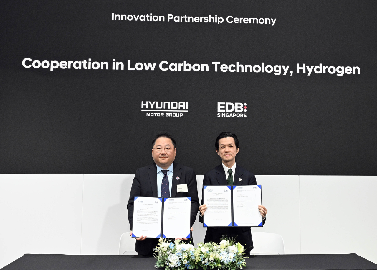 Park Jae-ha (left), senior vice president of the global hydrogen business subdivision at Hyundai Motor Group, and Clarence Chua, executive vice president of the Singapore Economic Development Board, pose for a photo on Friday after their innovation partnership ceremony on the sidelines of the APEC summit on Friday in Gyeongju, North Gyeongsang Province. (Hyundai Motor Group)