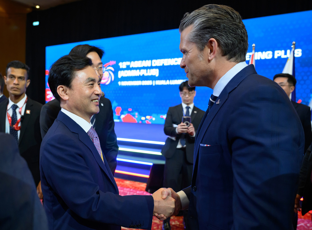 Defense Minister Ahn Gyu-back (L) and US Defense Secretary Pete Hegseth shake hands during the ASEAN Defense Ministers' Meeting-Plus in Kuala Lumpur on Saturday. (Defense Ministry via Yonhap)