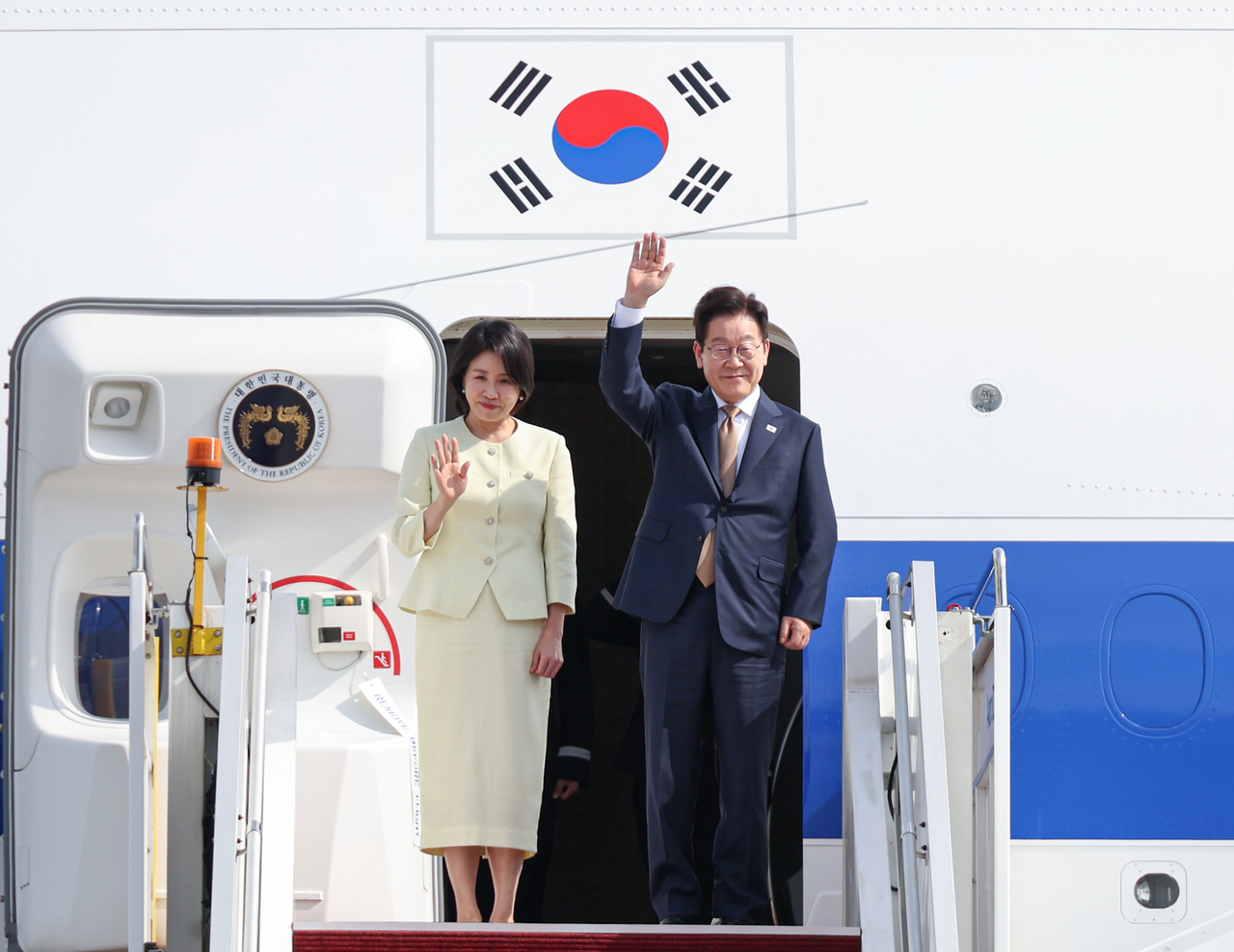 President Lee Jae Myung and First Lady Kim Hye Kyung wave to well-wishers as they board the presidential jet at Kuala Lumpur International Airport in Malaysia on Monday, wrapping up their schedule for the ASEAN summit. (Yonhap)