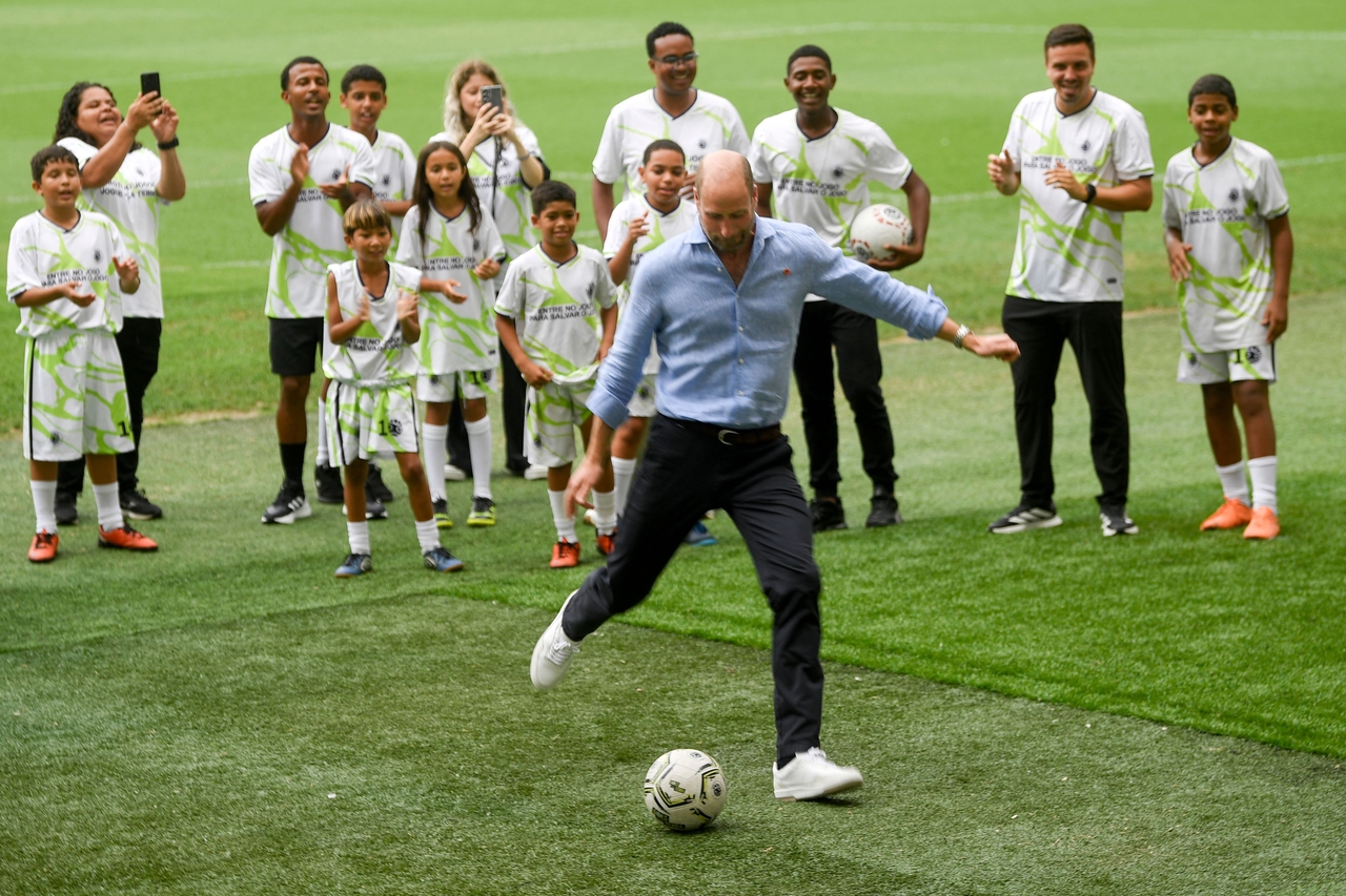 Britain's Prince William (center), Prince of Wales, kicks the ball during a community soccer event at Maracana Stadium in Rio de Janeiro, Brazil, Monday.   (AFP-Yonhap)