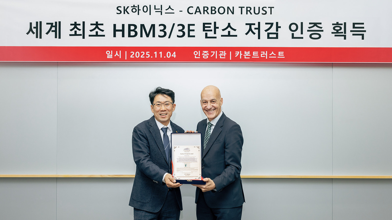 SK hynix’s Manufacturing Technology Head Lee Byoung-ki (left) and Carbon Trust’s Managing Director Hugh Jones pose for a photo during a certificate award ceremony on Tuesday at SK hynix headquarters in Icheon, Gyeonggi Province. (SK hynix)