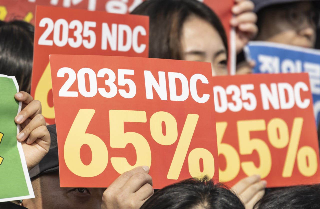 Environmental activists call for the South Korean government to adopt a 65 percent cut in greenhouse gas emissions as its 2035 Nationally Determined Contribution in front of the National Assembly building in Yeouido, Seoul, Thursday. (Yonhap)