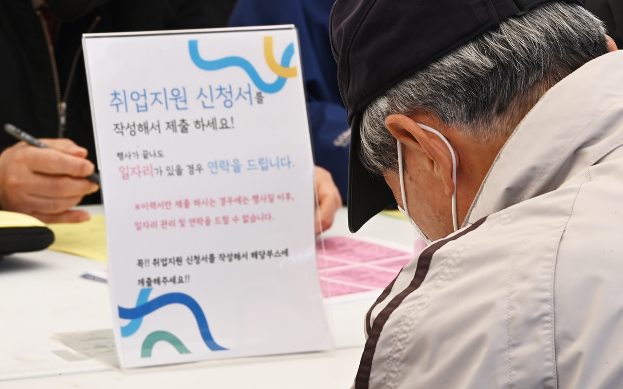 An job seeker fills out an employment support application at a senior job fair in Suwon, south of Seoul, in March this year. (Newsis)