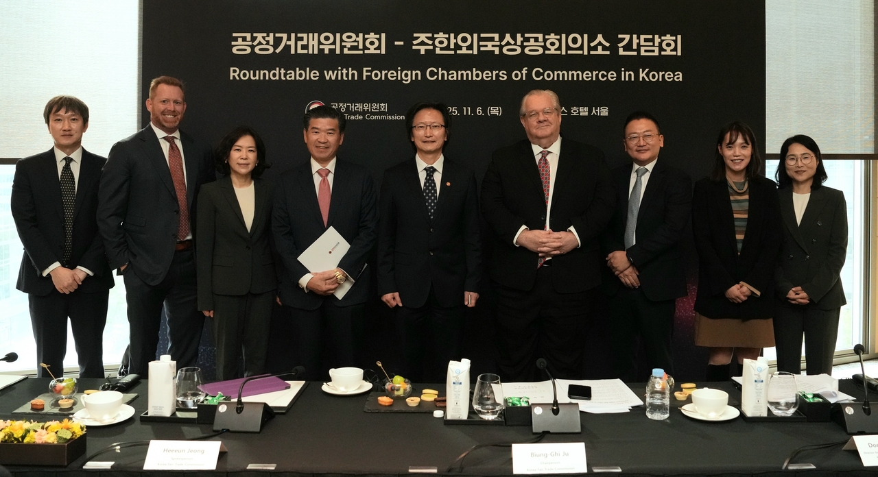 American Chamber of Commerce in Korea Chair and CEO James Kim (fourth from left), Fair Trade Commission Chair Ju Biung-ghi (center) and other participants pose for a photo at a roundtable on Thursday at the Four Seasons Hotel Seoul. (AmCham)