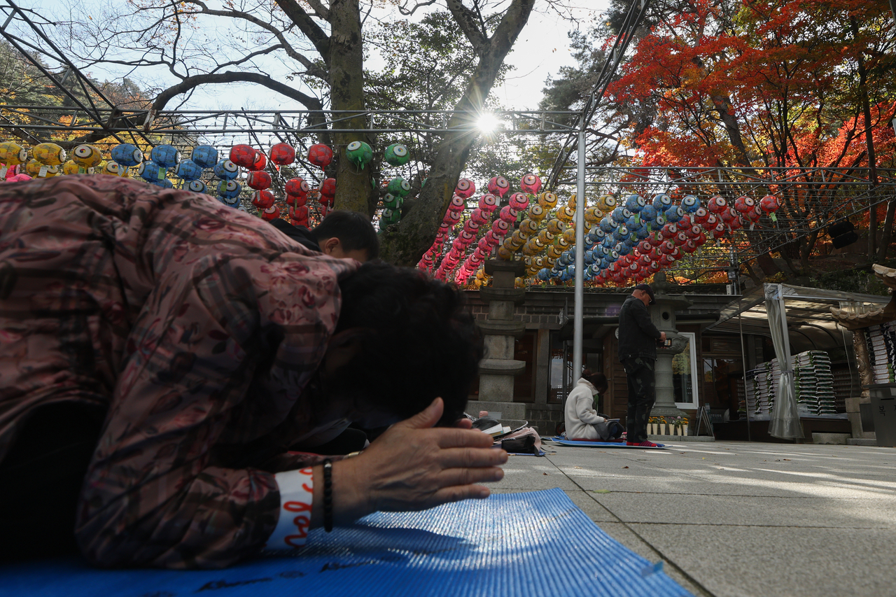 A grandparent prays for their grandchildren's success during a prayer session held Sunday at Doseonsa in Gangbuk-gu, northern Seoul. (Yonhap)