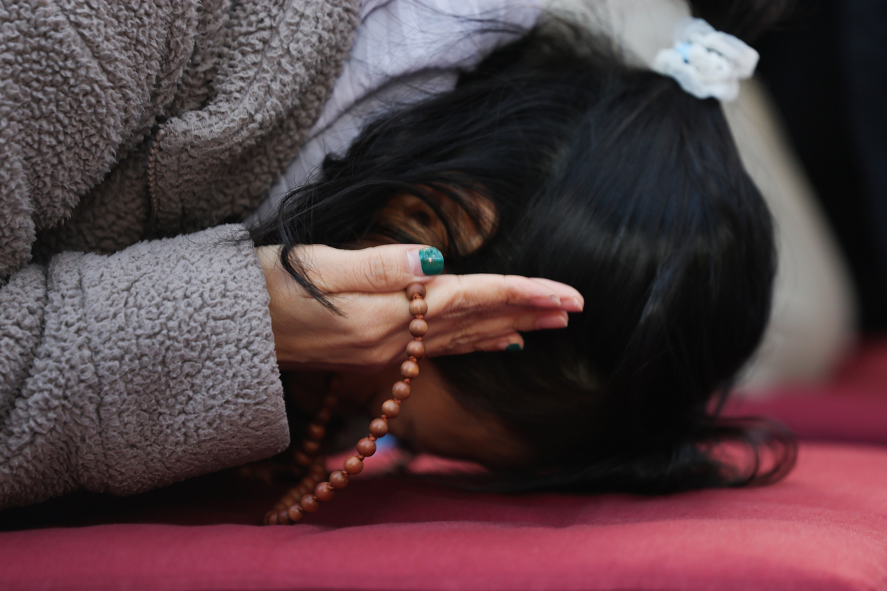 A mother prays using prayer beads on Sunday at Doseonsa in Gangbuk-gu, northern Seoul. (Yonhap)