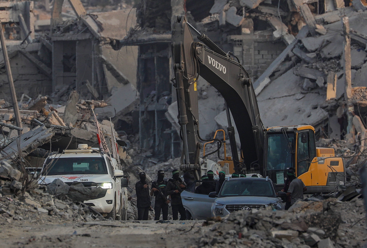 Hamas fiighters stand guard as they search for the bodies of Israeli hostages in the Gaza Strip, Wednesday. (EPA-Yonhap)