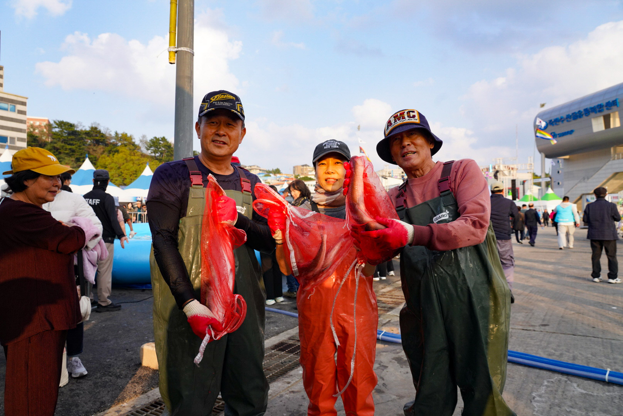 죽변항 수산물축제에서 맨손활어잡기 체험에 참여한 관광객들이 즐거워 하고 있다.[울진군 제공]