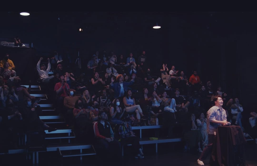 Audience watch as a controller plays a game during "asses.masses." (asses.masses official website)