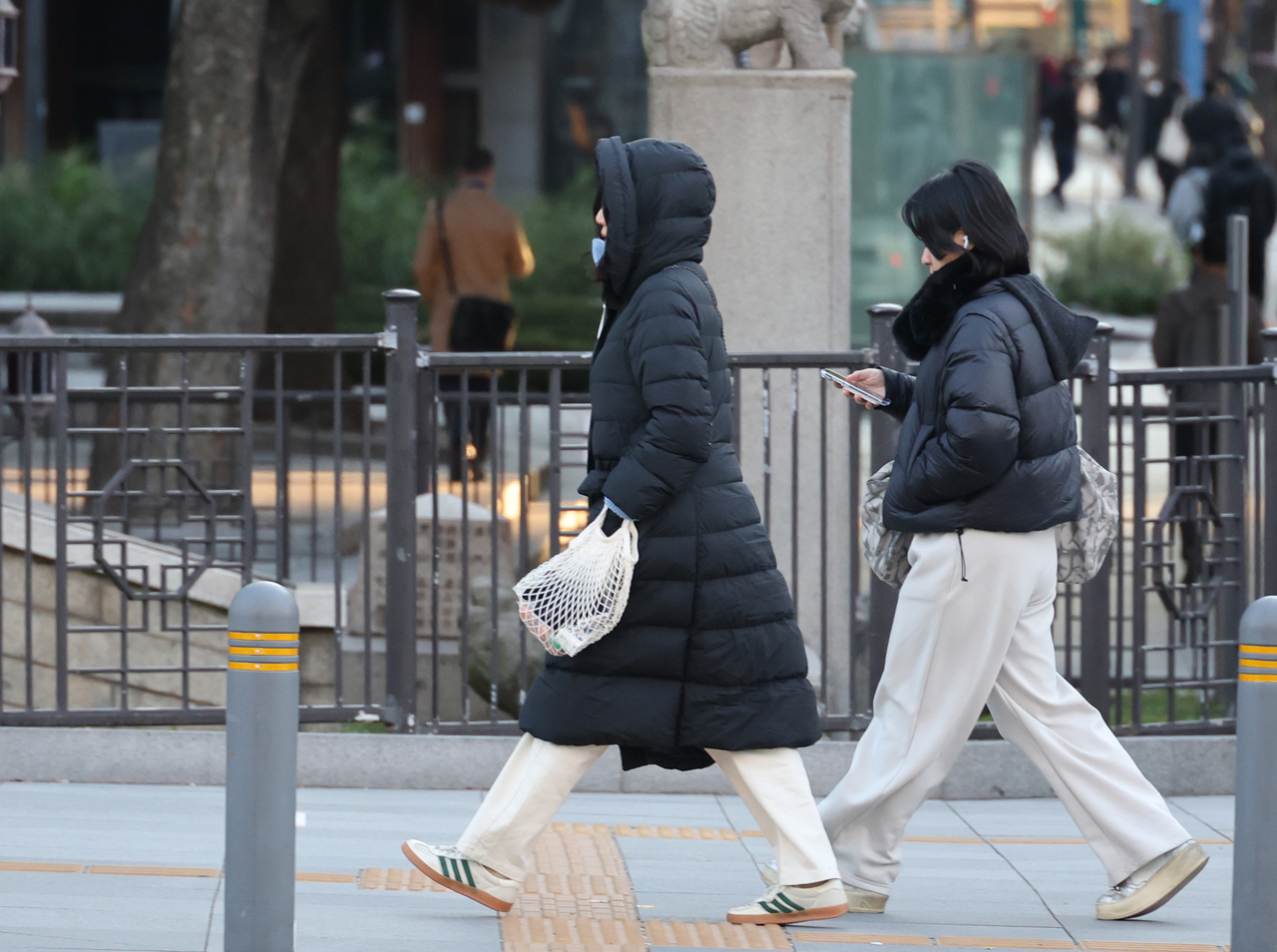 Pedestrians dressed in thick, padded winter jackets walk the streets of Seoul on Nov. 3, the same day a cold wave advisory was issued in the city for the first time this fall season. (Yonhap)