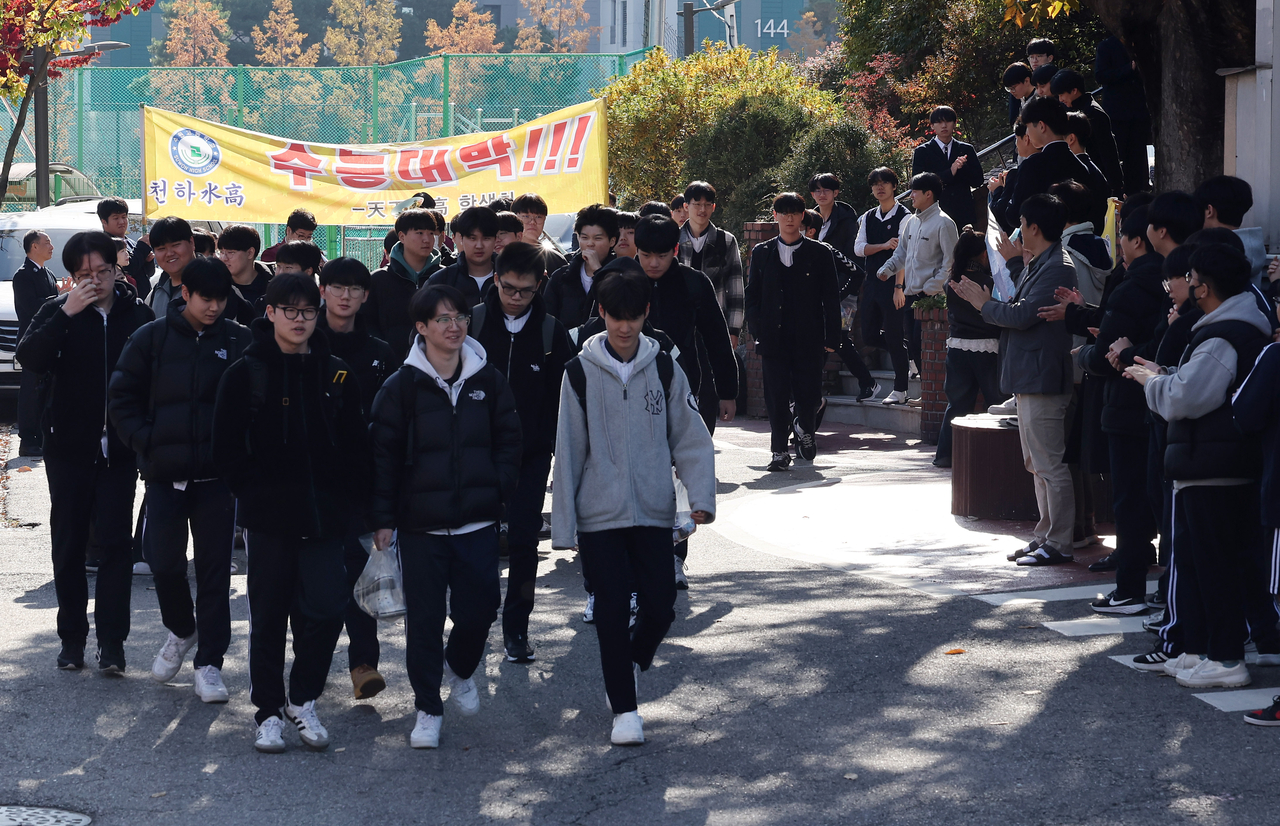 Senior high school students exit the school ground at Suwon, Gyeonggi Province,  getting cheers from the students, two days ahead of Suneung, the College Scholastic Ability Test, (Yonhap)