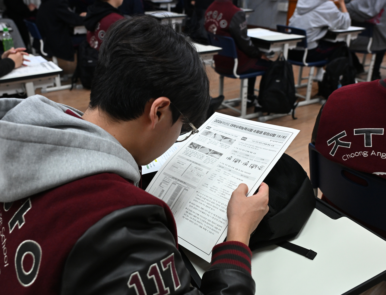 A senior student at Jungang High School in Jongno District, Seoul, reviews materials on the College Scholastic Ability Test guidelines on Wednesday, a day before the 2026 exam. (Yonhap)