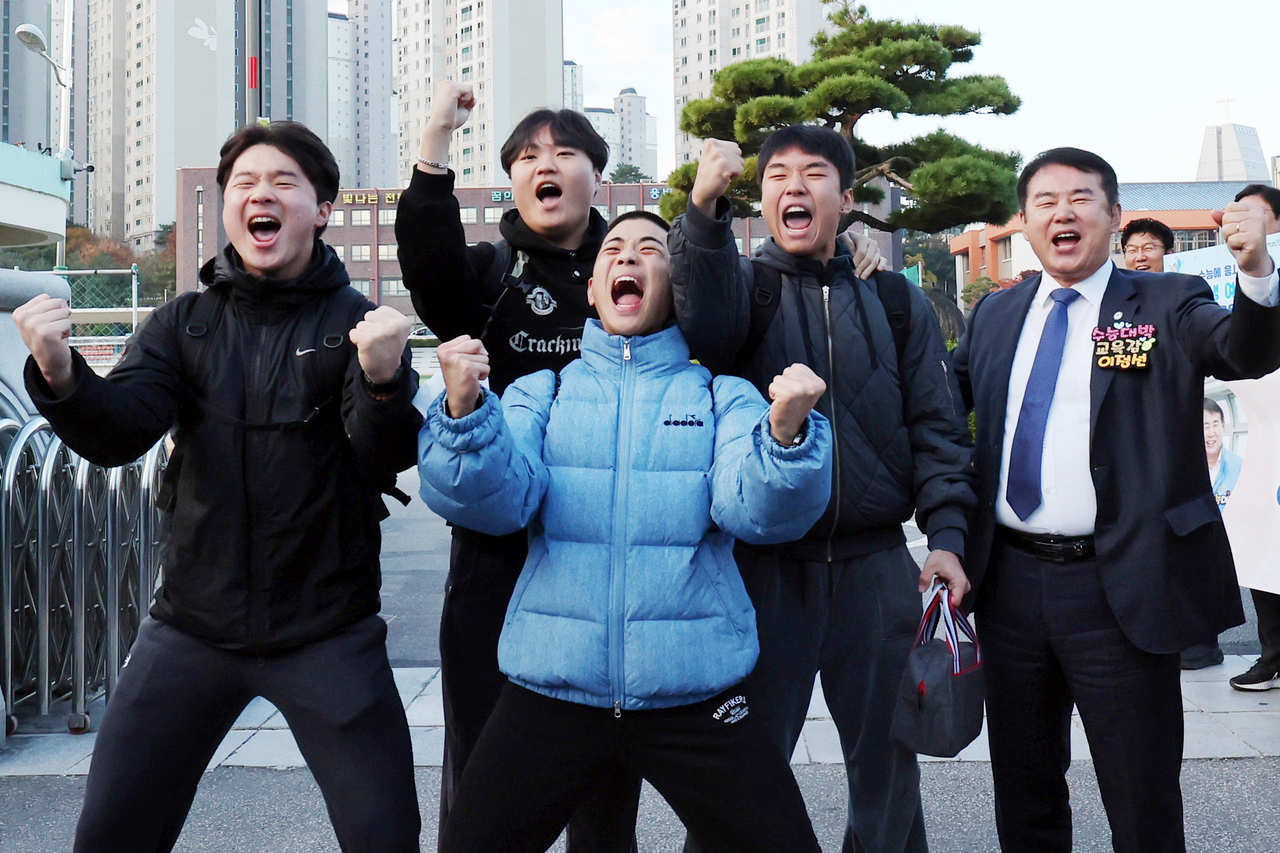 Students cheer with Lee Jung-seon, superintendent of the Gwangju Metropolitan Office of Education, in front of the main gate of Seoseok High School in Seo-gu, Gwangju, where a test center was set up for the 2026 CSAT on Thursday. (Yonhap)