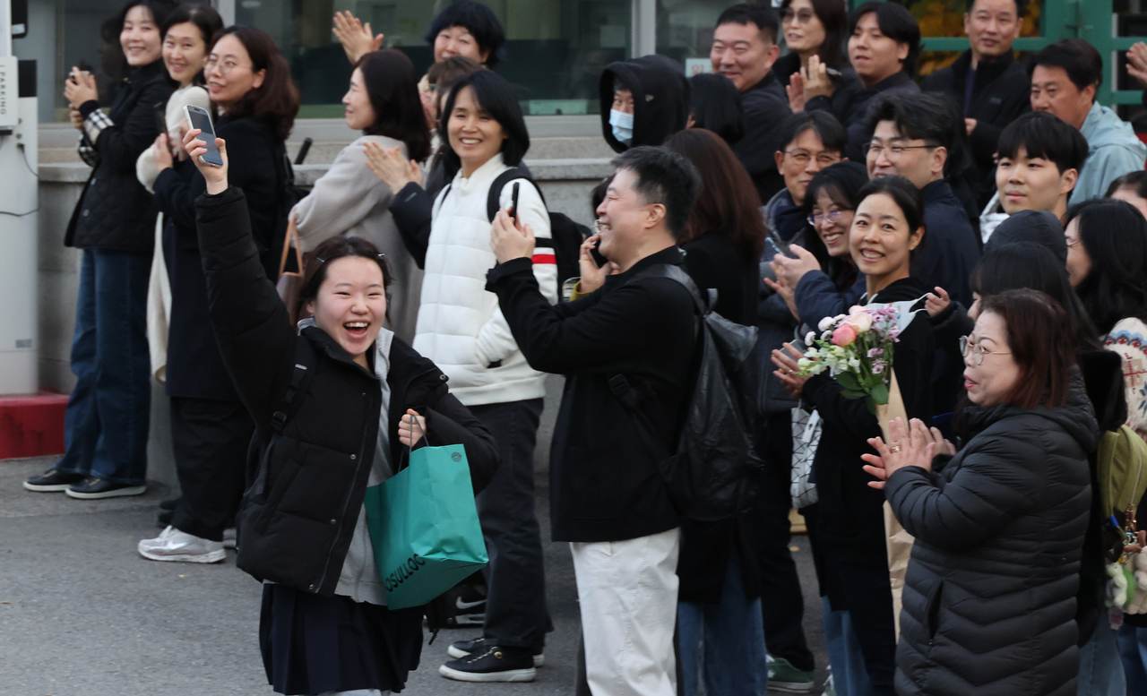 Students who finished taking the 2026 College Scholastic Ability Test (CSAT) on Thursday are greeted by their families and friends in front of Ewha Girls’ Foreign Language High School in central Seoul. (Yonhap)