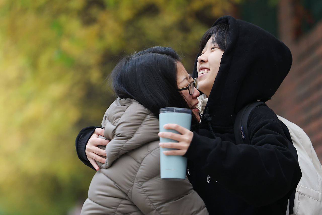 A parent hugs a student in front of Ewha Girls’ Foreign Language High School in Jung-gu, Seoul, on Thursday, the day of the 2026 College Scholastic Ability Test. (Yonhap)