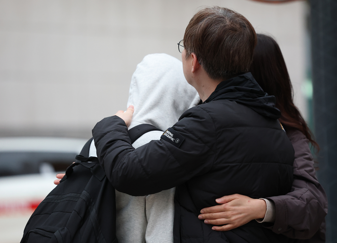 A parent hugs a student in front of Ewha Girls’ Foreign Language High School in Jung-gu, Seoul, on Thursday, the day of the 2026 College Scholastic Ability Test. (Yonhap)