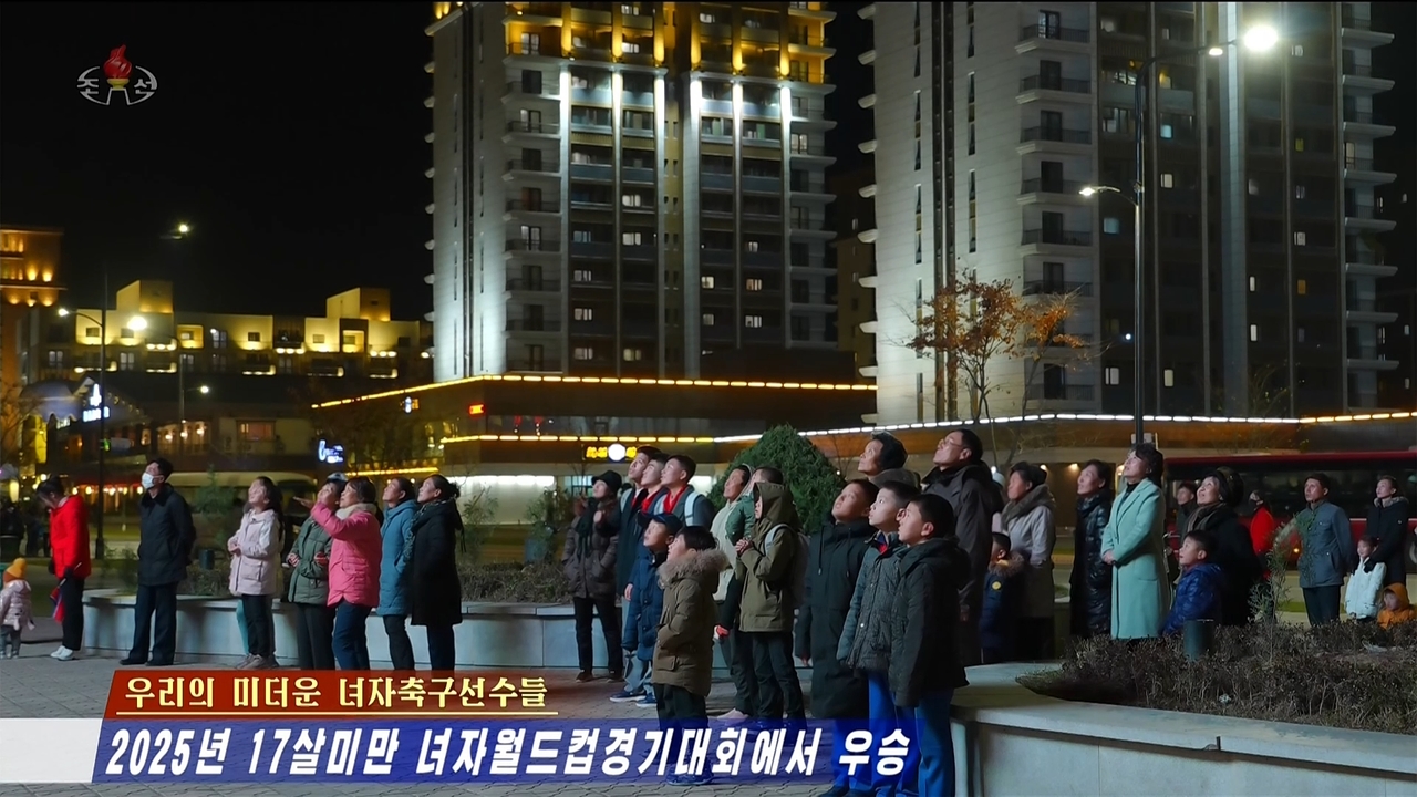 This screenshot from the Korean Central Television's Tuesday broadcast shows North Koreans watching a large outdoor screen as the country's national Under-17 women's football team plays the Netherlands during the World Cup finals. (Yonhap)