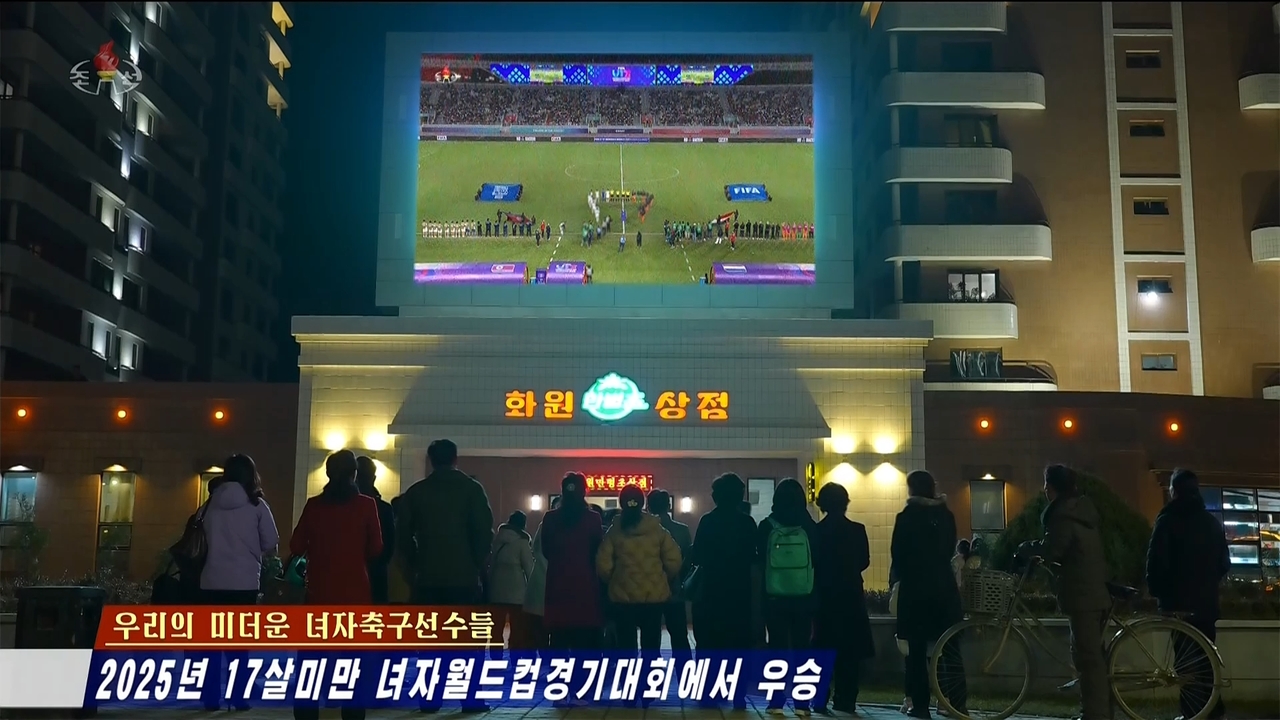 This screenshot from the Korean Central Television's Tuesday broadcast shows North Koreans watching a large outdoor screen as the country's national Under-17 women's football team plays the Netherlands during the World Cup finals. (Yonhap)