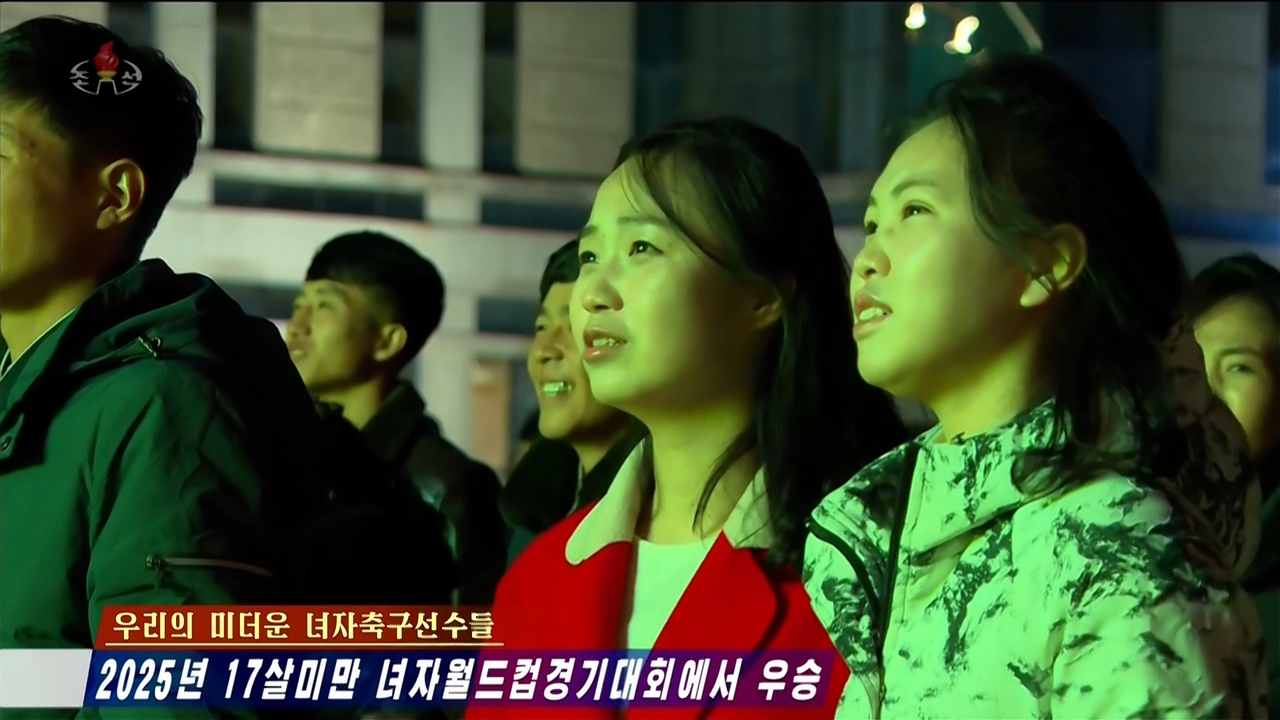 This screenshot from the Korean Central Television's Tuesday broadcast shows North Koreans watching a large outdoor screen as the country's national Under-17 women's football team plays the Netherlands during the World Cup finals. (Yonhap)
