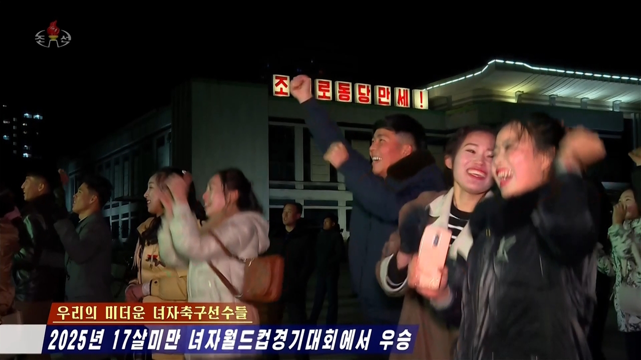 This screenshot from the Korean Central Television's Tuesday broadcast shows North Koreans celebrating in front of a large outdoor screen as the country's national Under-17 women's football team scores against the Netherlands during the World Cup finals. (Yonhap)
